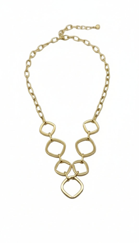 Gold chain necklace on a light gray background