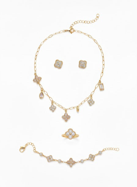 Gold jewelry set with necklace, bracelet, and earrings on a white background
