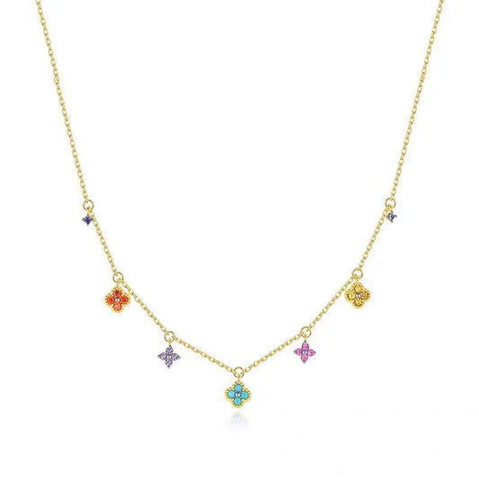 Gold necklace with colorful gemstone pendants on a white background