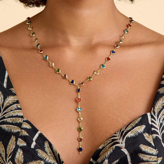 Multicolored beaded necklace on a model wearing a patterned dress.